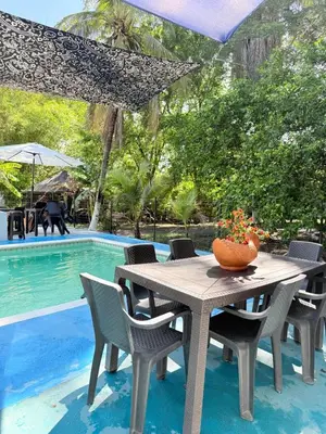 a table and chairs next to a swimming pool at Siboney family in Honda