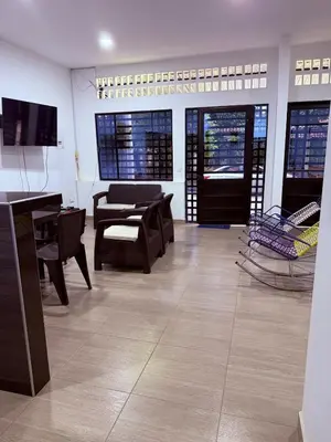 a living room with tables and chairs and a television at Casa encanto, jacuzzi privado & wifi in Mariquita