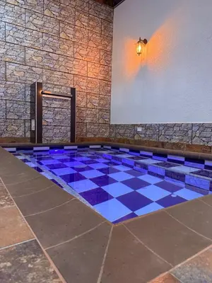 a swimming pool with a blue and white checkered floor at Casa encanto, jacuzzi privado & wifi in Mariquita