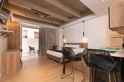 a room with a bed and a table and chairs at Opera Living by HOUSY in Medellín
