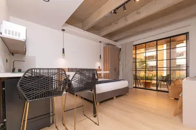 a bedroom with a bed and a table and chairs at Opera Living by HOUSY in Medellín