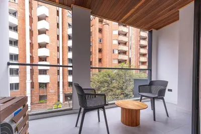 two chairs and a table in a room with a large window at Opera Living by HOUSY in Medellín