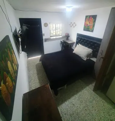 a small bedroom with a bed and a window at Apartaestudio en laureles la castellana in Medellín