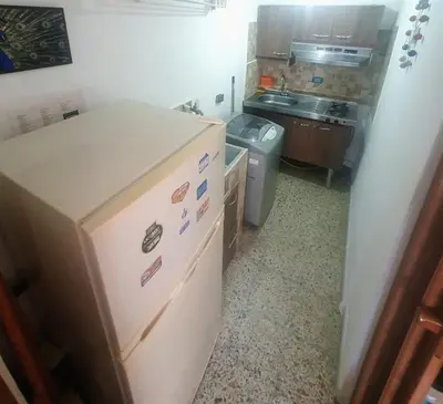a small kitchen with a refrigerator and a sink at Apartaestudio en laureles la castellana in Medellín