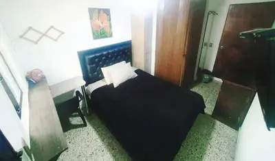 a bedroom with a black bed with a pillow at Apartaestudio en laureles la castellana in Medellín