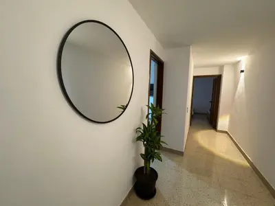 a mirror on a wall with a plant in a hallway at Apartamento en Laureles- Avenida Nutibara in Medellín