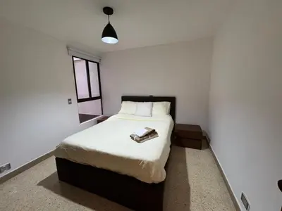 a bedroom with a bed in a white room at Apartamento en Laureles- Avenida Nutibara in Medellín