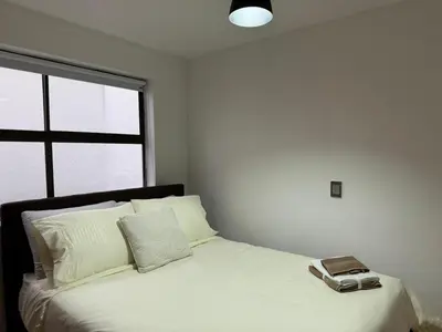a bedroom with a bed with a phone on it at Apartamento en Laureles- Avenida Nutibara in Medellín