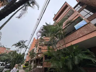 a woman walking down a street next to a building at Apartamento en Laureles- Avenida Nutibara in Medellín