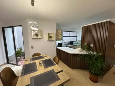 a living room with a table and a kitchen at Apartamento en Laureles- Avenida Nutibara in Medellín