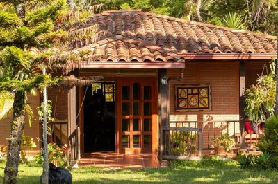 a house with a cat sitting outside of it at El Paraíso Tropical in La Pradera