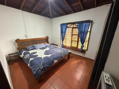 a bedroom with a bed and a window at El Paraíso Tropical in La Pradera