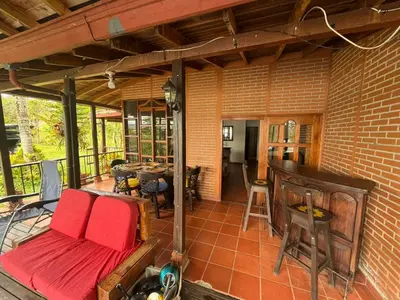 a screened in porch with a couch and a table at El Paraíso Tropical in La Pradera