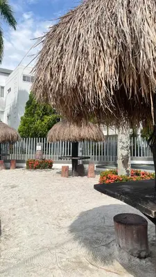 a straw umbrella and a bench in a courtyard at Hermoso Apartasol en Santa Fe de Antioquia!!! in Santa Fe de Antioquia