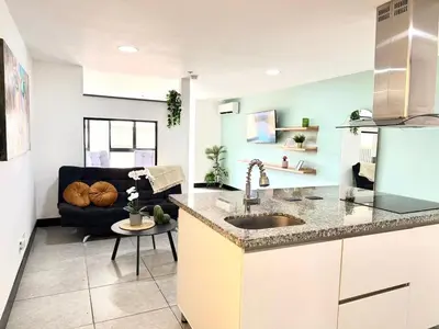 a kitchen with a sink and a living room at Cozy Studio 703 Heart of Laureles in Medellín