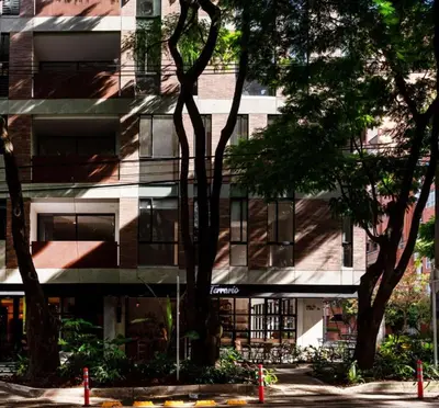 an apartment building with trees in front of it at Cozy Studio 703 Heart of Laureles in Medellín
