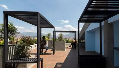 a woman sitting on a bench on a roof at Cozy Studio 703 Heart of Laureles in Medellín
