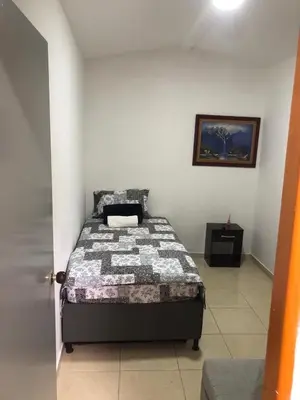 a bedroom with a bed in a white room at Individual studio apartment 2 in Medellín