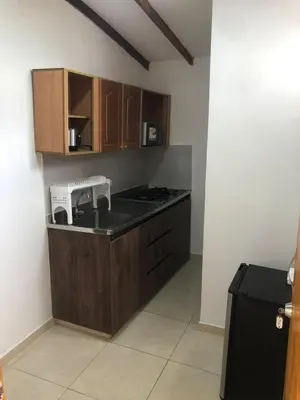 a kitchen with wooden cabinets and a counter top at Individual studio apartment 2 in Medellín