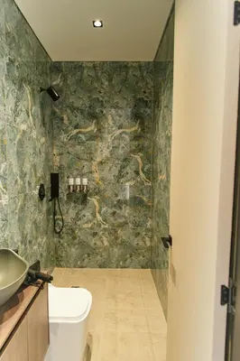 a bathroom with a shower and a toilet and a sink at Roka Hotel in Guatapé
