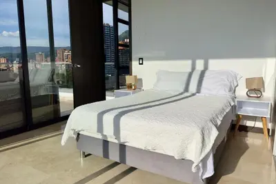 a bedroom with a bed and a large window at 2003 Poblado TOP apartamento in Medellín