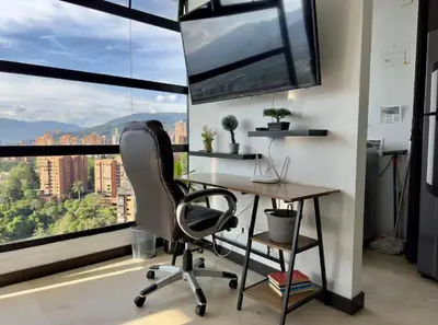 an office with a desk and a chair in front of a window at 2003 Poblado TOP apartamento in Medellín