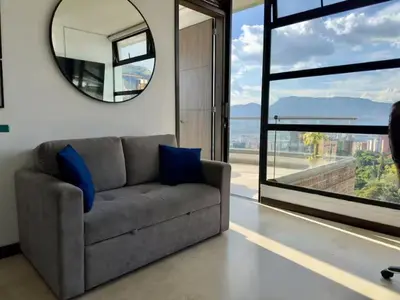 a living room with a couch and a mirror at 2003 Poblado TOP apartamento in Medellín