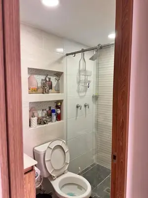 a bathroom with a toilet and a glass shower at Espectacular Habitacion Privada en Apartamento in Medellín