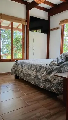 a bedroom with a bed in a room with windows at Rural Cabin Among Clouds in Támesis