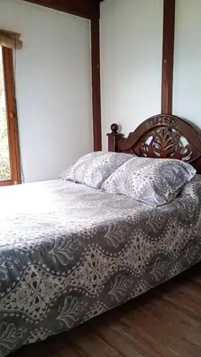 a bedroom with a bed with a wooden headboard at Rural Cabin Among Clouds in Támesis
