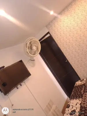 a room with a fan and a bed at Habitación Amoblada in Medellín