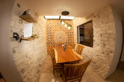 a dining room with a wooden table and chairs at Acogedora casa Refugio del Altisimo in Medellín
