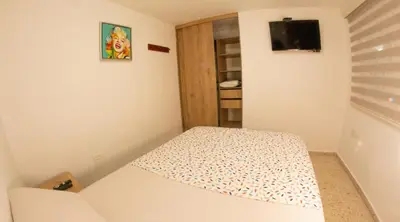 a small room with a bed and a television at Acogedora casa Refugio del Altisimo in Medellín