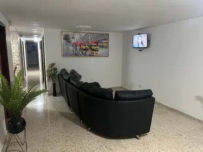 a living room with black leather couches in a room at Acogedora casa Refugio del Altisimo in Medellín