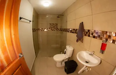 a bathroom with a toilet and a sink at Acogedora casa Refugio del Altisimo in Medellín