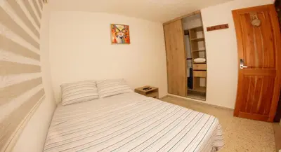a bedroom with a bed with a striped comforter at Acogedora casa Refugio del Altisimo in Medellín