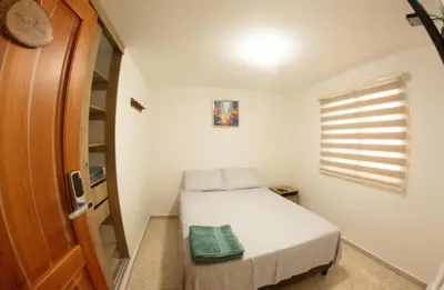 a small bedroom with a bed and a window at Acogedora casa Refugio del Altisimo in Medellín
