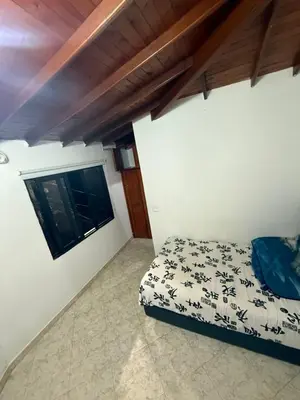 a small bedroom with a bed and a window at Casa Village in Guatapé