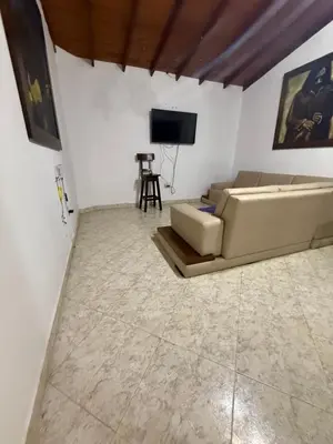 a living room with a couch and a television at Casa Village in Guatapé