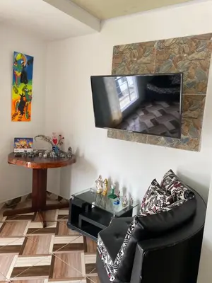 a living room with a tv and a chair and a table at Apartamento Bustos 1 in Puerto Triunfo