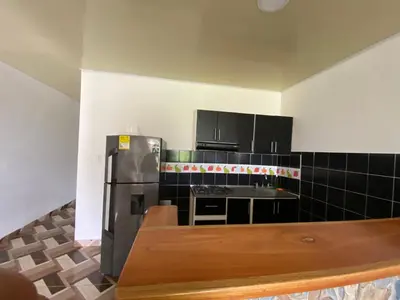 a kitchen with a stainless steel refrigerator and black cabinets at Apartamento Bustos 1 in Puerto Triunfo