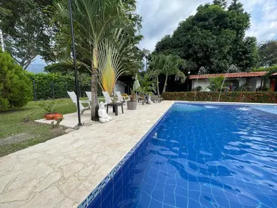 a swimming pool in a yard with chairs and trees at Villa with pool, jacuzzi, Turkish bath, BBQ, kiosk, and green area in Sopetran