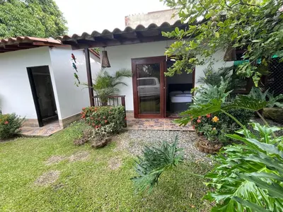 a house with a door and a yard with plants at Villa with pool, jacuzzi, Turkish bath, BBQ, kiosk, and green area in Sopetran