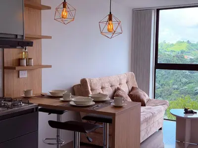 a living room with a couch and a table and a kitchen at Nuevo apartamento moderno, espectacular vista in Manizales