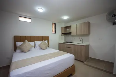 a bedroom with a bed and a sink in it at Apartahotel Ces in Medellín