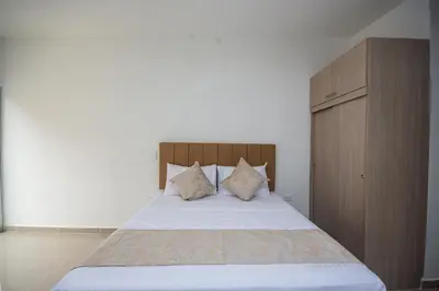 a bedroom with a bed with a wooden headboard and pillows at Apartahotel Ces in Medellín