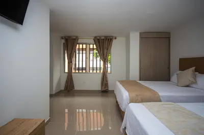 a hotel room with two beds and a window at Apartahotel Ces in Medellín