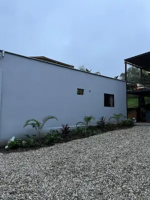 a white building with plants on the side of it at Casa Moderna en el Bosque Jacuzzi y Deck Privado in Mazo