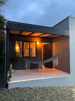 a house with a hammock in front of it at Casa Moderna en el Bosque Jacuzzi y Deck Privado in Mazo