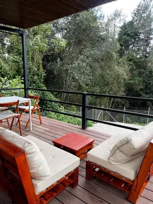a wooden deck with chairs and a table and a table at Casa Moderna en el Bosque Jacuzzi y Deck Privado in Mazo
